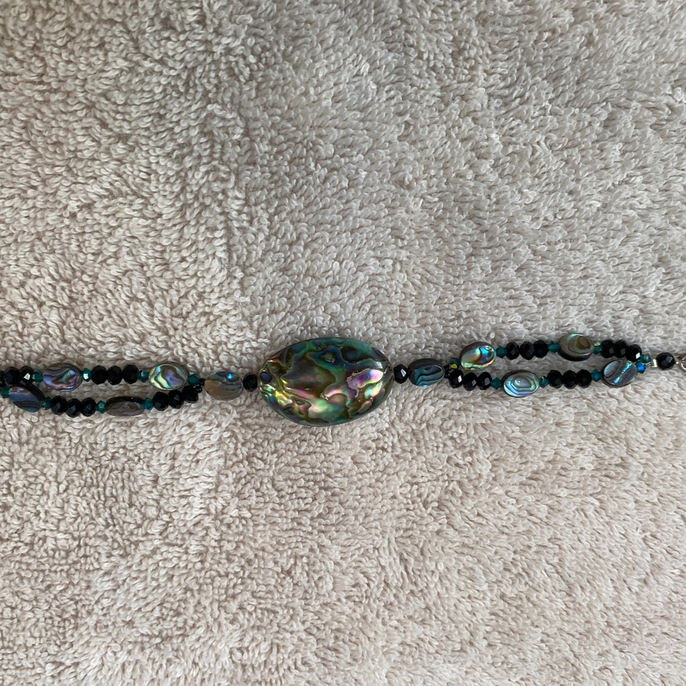 Beaded bracelet featuring abalone shell nuggets, black beads, and a toggle clasp